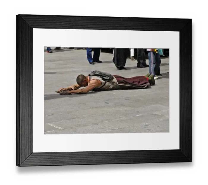 Framed Print : Tibetan pilgrim lies on the ground praying