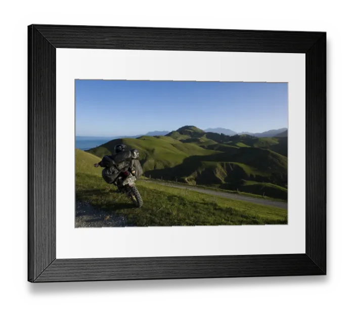 Framed Print : Heavily laden enduro motorbike in a green hilly landscape