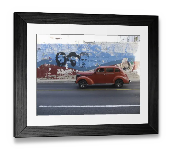 Framed Print : American vintage car driving along a wall with paintings of Fidel Castro and Che Guevara
