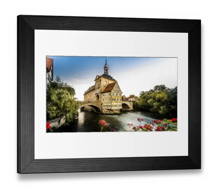 Framed Print : Half-timbered house on bridge over river with dramatic sky and sunset lighting