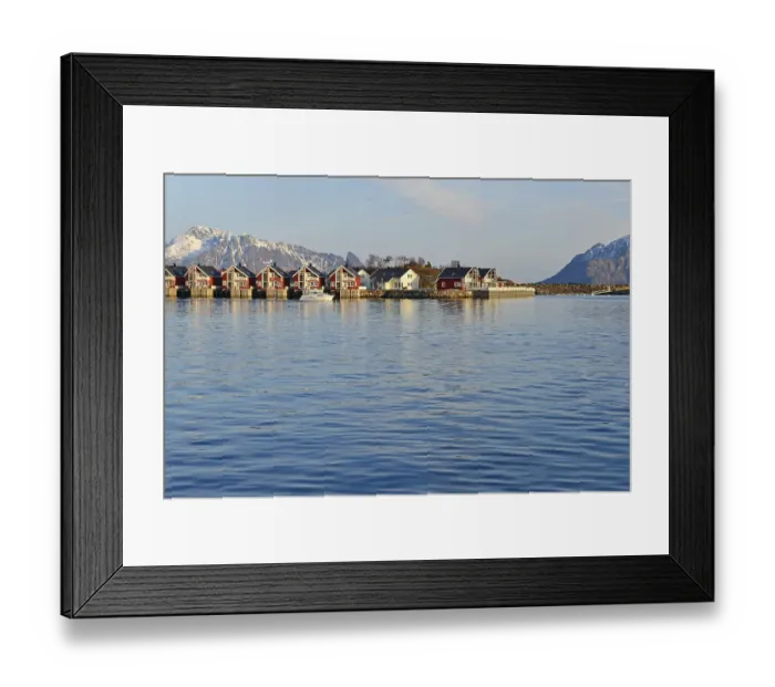 Framed Print : Row of red cottages by the blue water