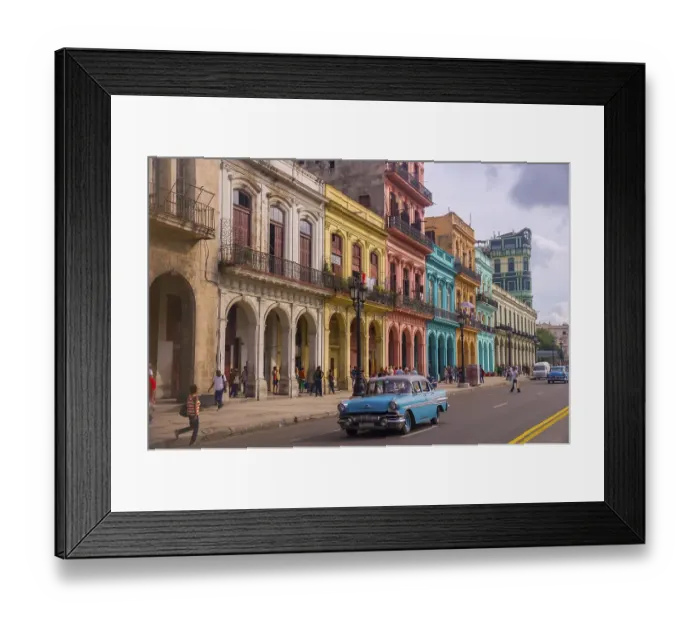 Framed Print : A blue oldtimer taxi is driving through Habana Vieja in front of a colorful facade of colonial buildings Framed Print : A blue oldtimer taxi is driving through Habana Vieja in front of a colorful facade of colonial buildings