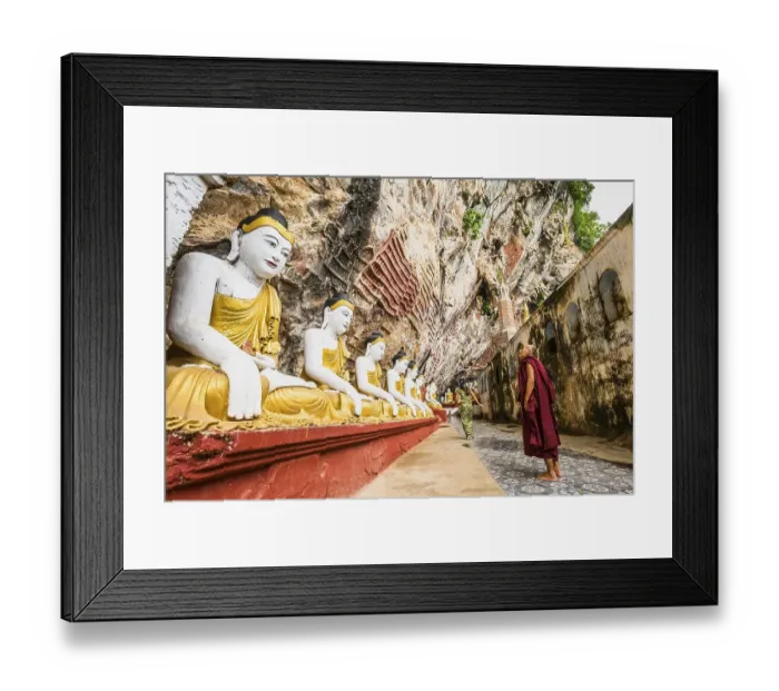 Framed Print : Monk looking at the seated Buddha statues Framed Print : Monk looking at the seated Buddha statues