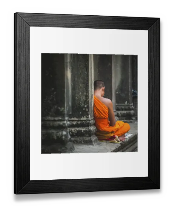 Framed Print : Buddhist monk meditates in colonnade