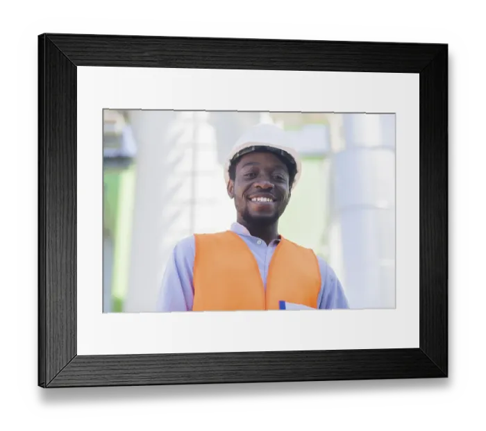 Framed Print : Young black man working outside as technician with helmet and safety vest Framed Print : Young black man working outside as technician with helmet and safety vest