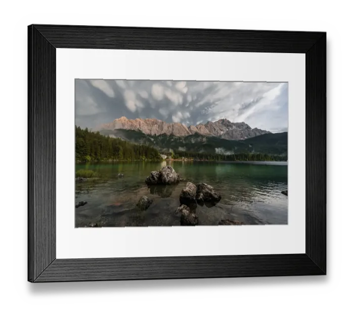 Framed Print : Rocks on the shore, Eibsee lake in front of Zugspitze massif with Zugspitze