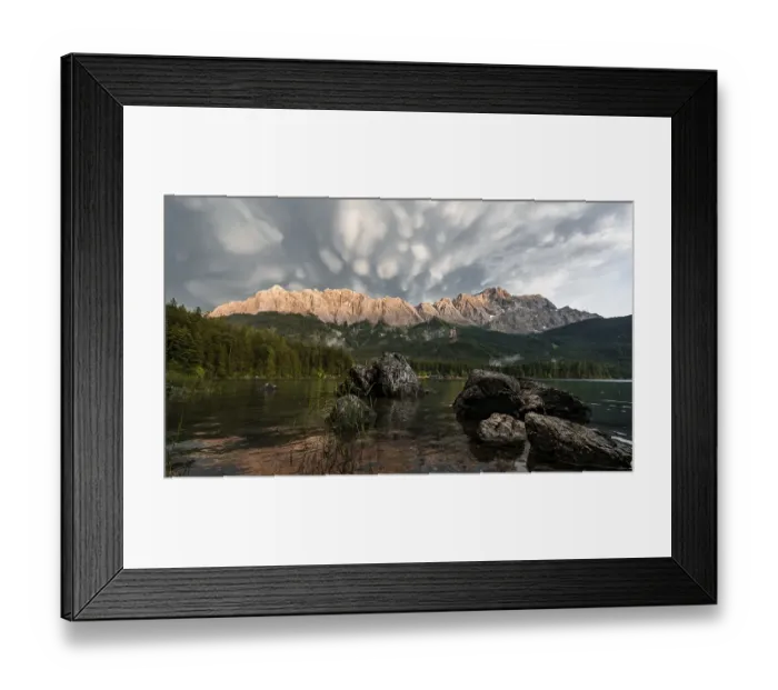 Framed Print : Rocks on the shore, Eibsee lake in front of Zugspitze massif with Zugspitze
