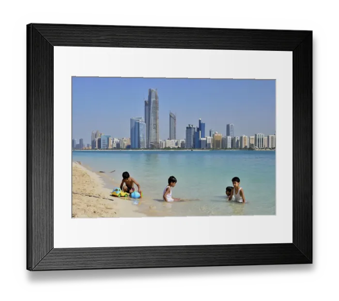 Framed Print : Children playing in water, Abu Dhabi skyline in the back