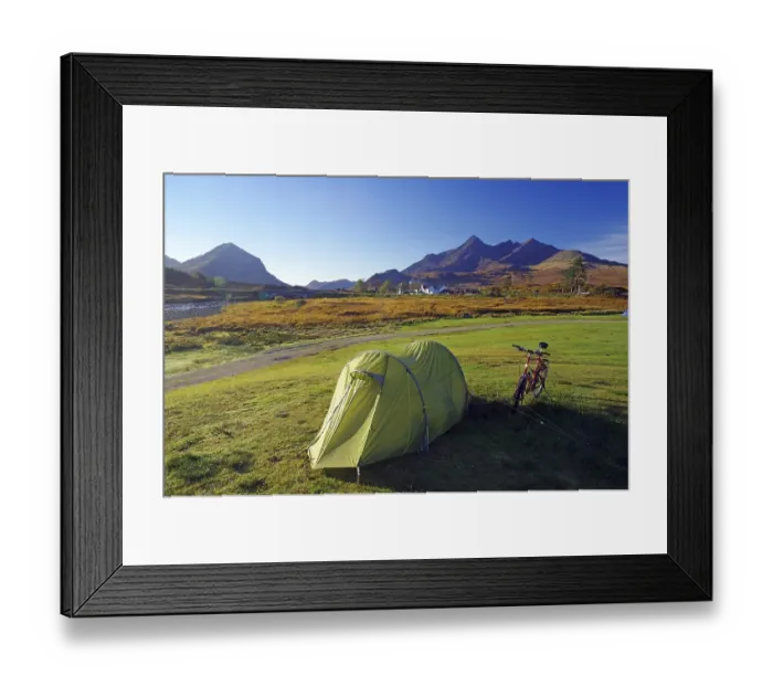 Framed Print : A tent and a bicycle stand on a green meadow with mountains in the background Framed Print : A tent and a bicycle stand on a green meadow with mountains in the background