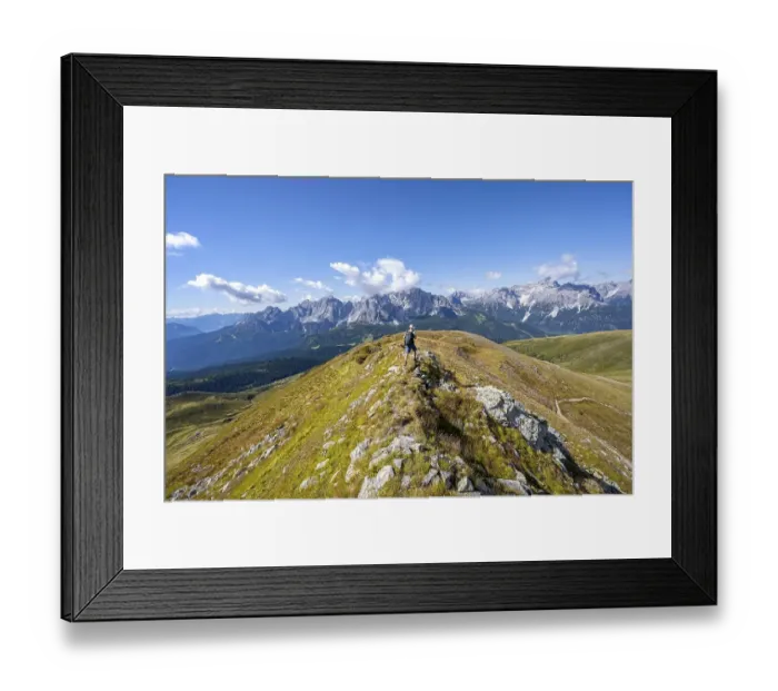 Framed Print : Mountaineers on a hiking trail between green mountain meadows on a mountain ridge