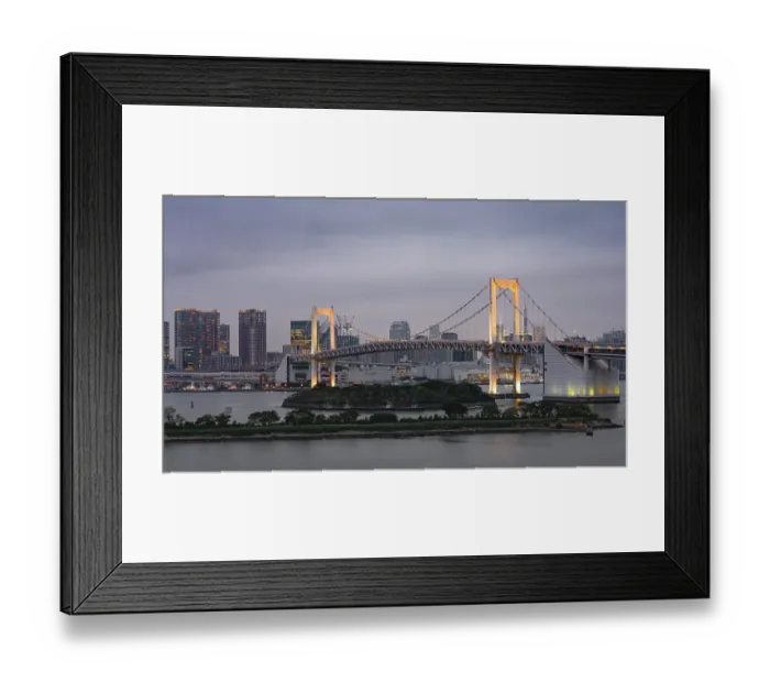 Framed Print : View of skyline with skyscrapers and illuminated Rainbow Bridge in the evening Framed Print : View of skyline with skyscrapers and illuminated Rainbow Bridge in the evening
