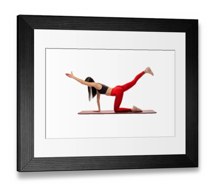 Framed Print : Side view of a flexible woman in sportswear standing on a mat and practising yoga on a white background