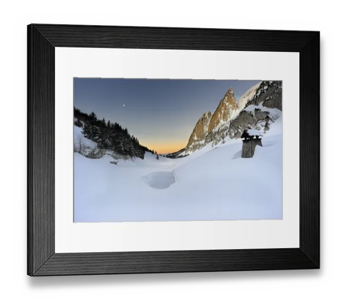 Framed Print : Snow-covered roof of a hut at sunrise