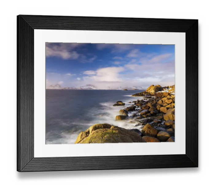Framed Print : Rocky coast, snow-capped mountains in the background Framed Print : Rocky coast, snow-capped mountains in the background