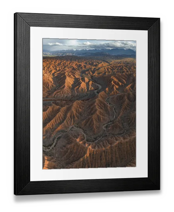 Framed Print : River bed runs through a landscape of eroded hills