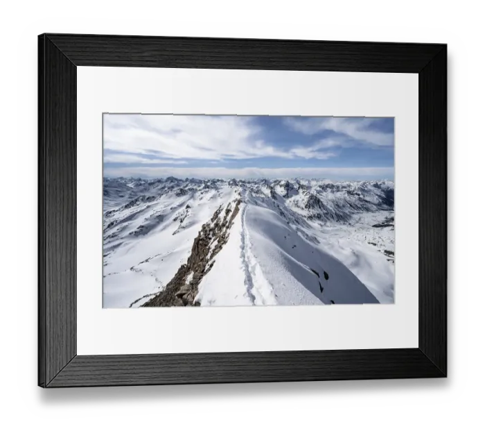 Framed Print : Tracks in the snow on a narrow mountain ridge in winter