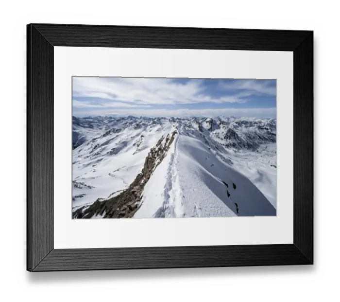 Framed Print : Tracks in the snow on a narrow mountain ridge in winter