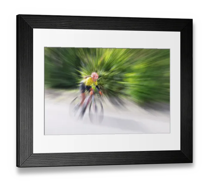 Framed Print : Cyclist in sportswear and helmet riding at high speed on a road Framed Print : Cyclist in sportswear and helmet riding at high speed on a road