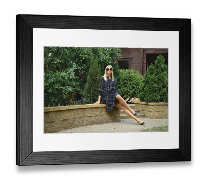 Framed Print : Fashionable confident woman in checkered dress sits in the garden Framed Print : Fashionable confident woman in checkered dress sits in the garden