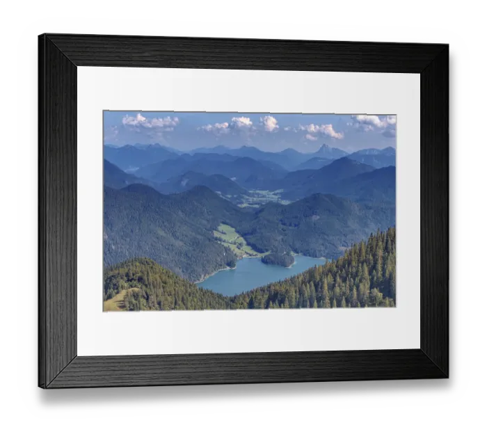 Framed Print : A wide panorama of mountains and valleys with extensive forests under a blue sky with clouds