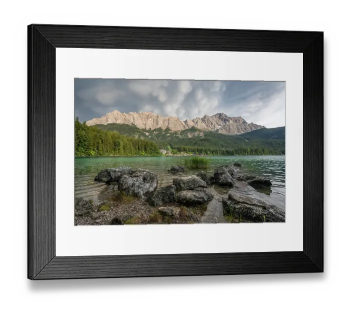 Framed Print : Rocks on the shore, Lake Eibsee lake in front of Zugspitze massif with Zugspitze