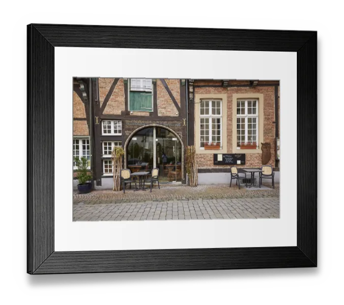 Framed Print : Entrance area of a restaurant in a historic half-timbered brick house with white
