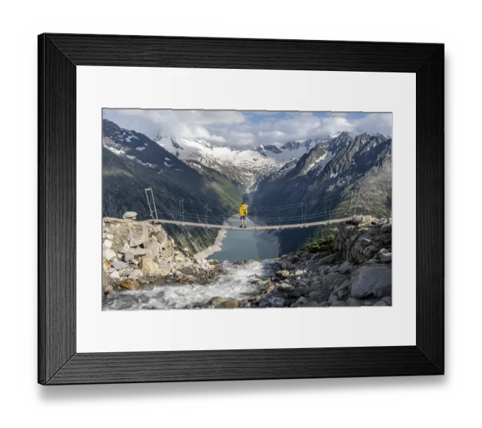 Framed Print : Mountaineers on a suspension bridge over a mountain stream Alelebach