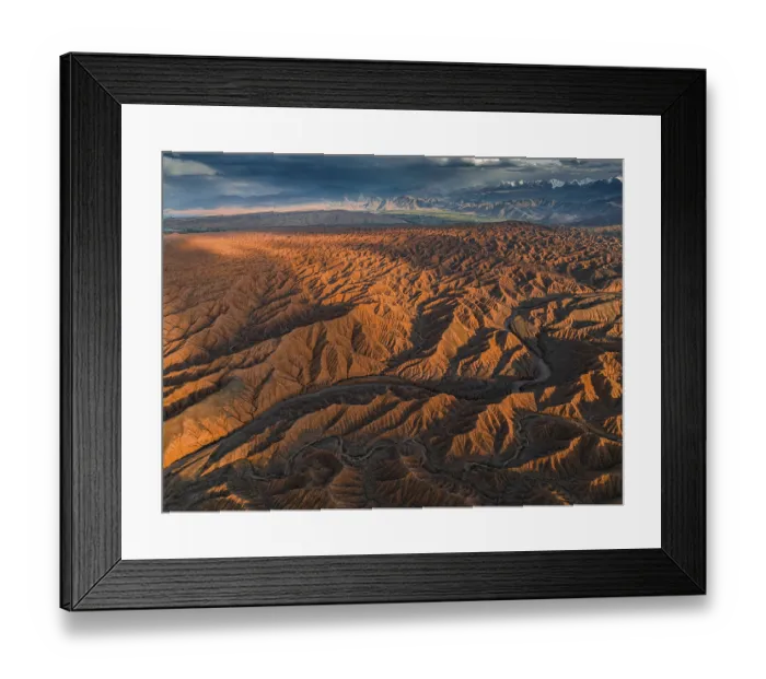 Framed Print : River bed runs through a landscape of eroded hills