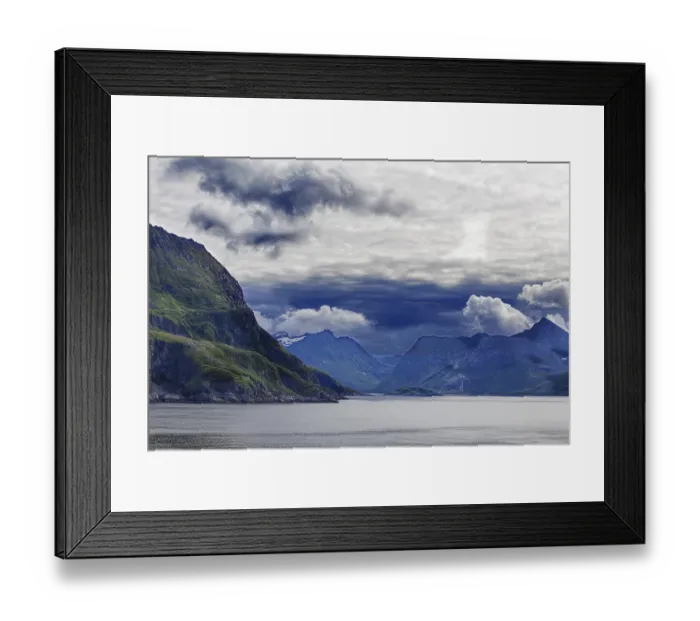 Framed Print : A fjord surrounded by green mountains under a dramatic cloudy sky