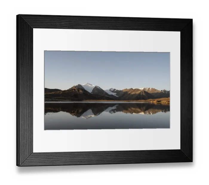 Framed Print : Glaciated mountain peaks reflected in a mountain lake at sunset