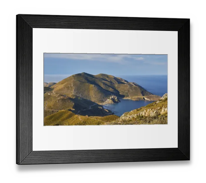 Framed Print : Sunny coastal road winding along a mountainous landscape overlooking the sea
