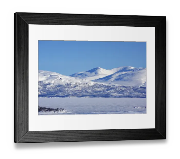 Framed Print : Snow-capped mountains and a frozen lake under a clear blue sky
