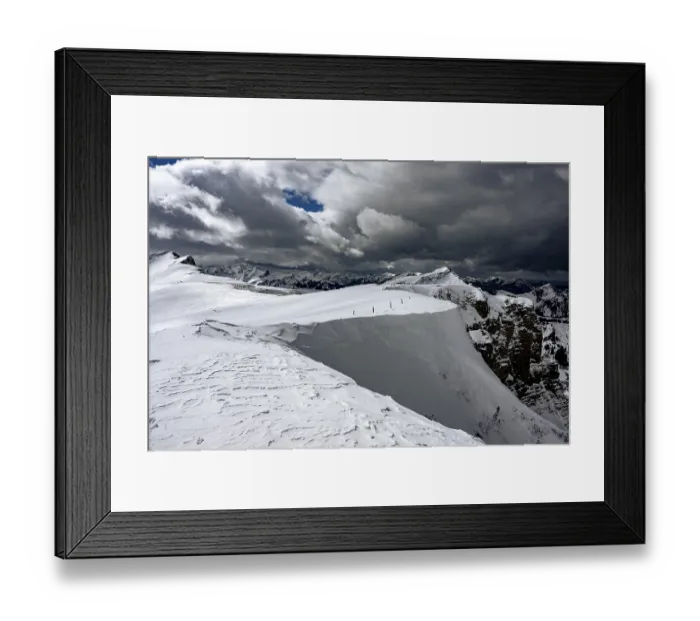 Framed Print : Berlinger Koepfl summit area with snow-covered mountains in the background and dramatic sky