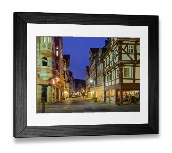 Framed Print : The Lange Strasse in the old town centre of Hannoversch Muenden with historic half-timbered houses in the evening