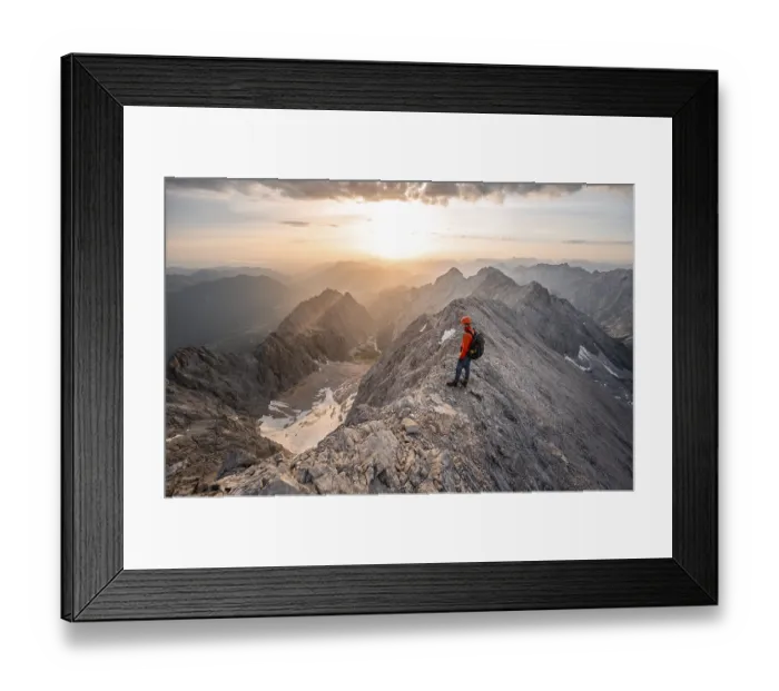 Framed Print : Mountaineer with helmet on a narrow rocky ridge at sunrise