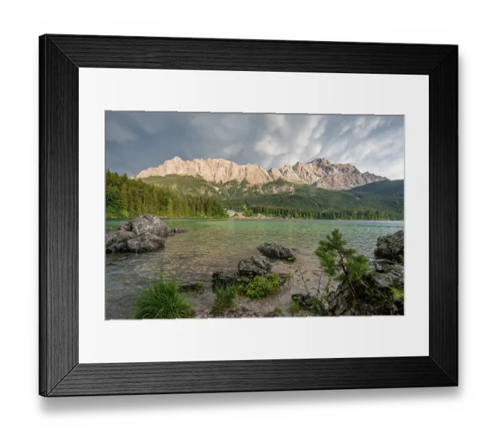 Framed Print : Rocks on the shore, Lake Eibsee lake in front of Zugspitze massif with Zugspitze