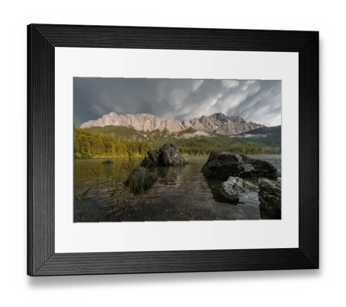 Framed Print : Rocks on the shore, Eibsee lake in front of Zugspitze massif with Zugspitze