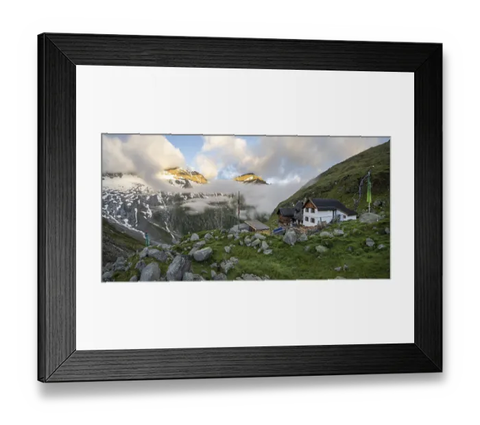Framed Print : Hiker looks at mountain peaks with last sunlight