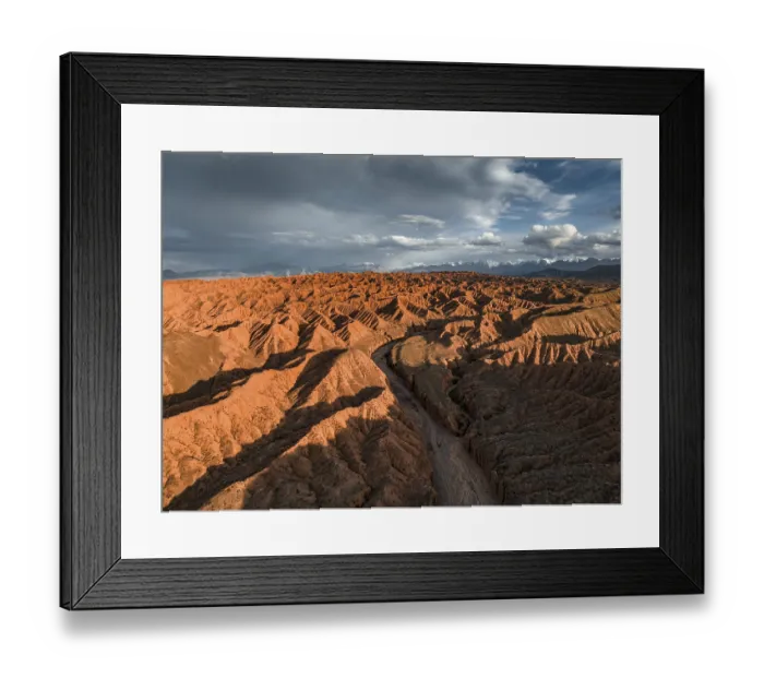 Framed Print : River bed runs through a landscape of eroded hills