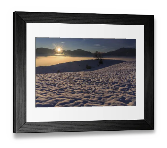 Framed Print : Sunrise over a snow-covered mountain landscape