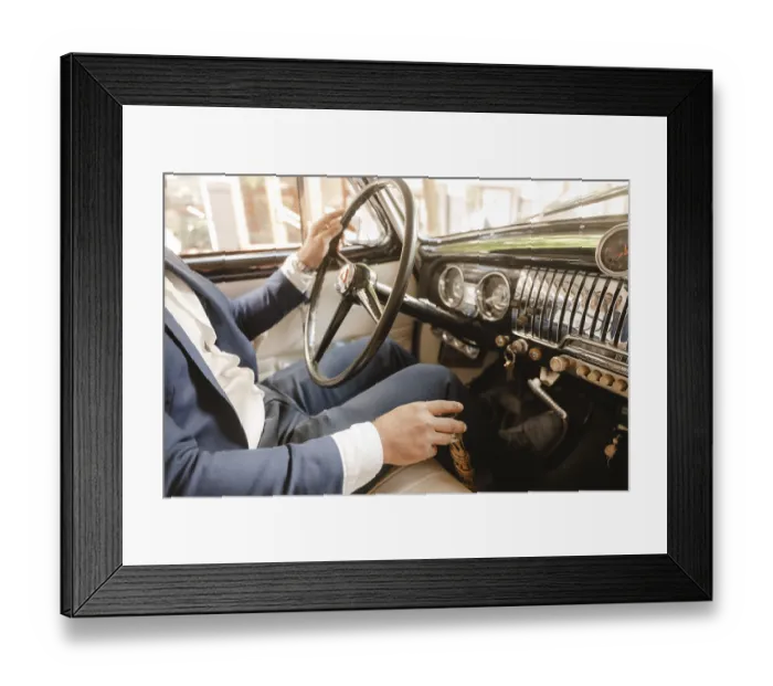 Framed Print : A man in a suit is driving a car with a black steering wheel