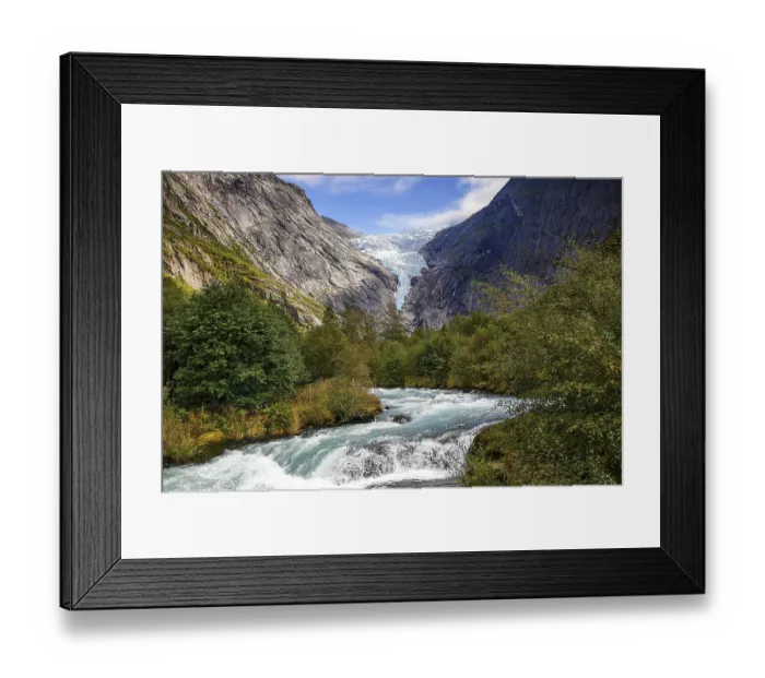 Framed Print : River flanked by mountains flows through a green valley with a view of the shimmering Briksdalsbreen glacier in Norway