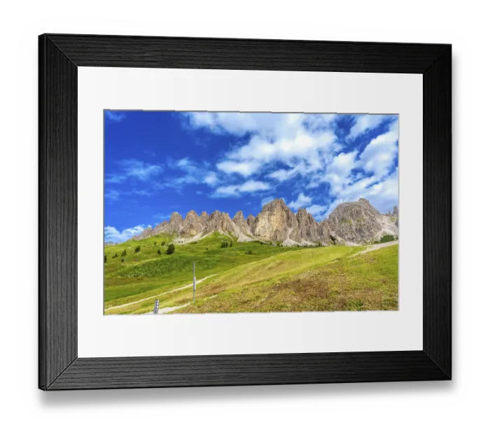 Framed Print : Green meadows and imposing peaks of the dolomites illuminated by the summer sun Framed Print : Green meadows and imposing peaks of the dolomites illuminated by the summer sun