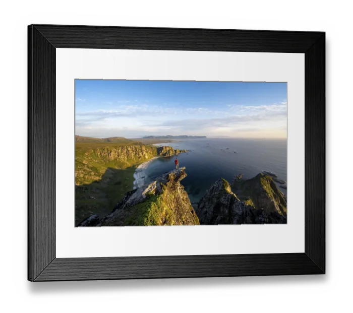 Framed Print : Evening mood, mountaineer standing on a rocky outcrop on the summit of Matind