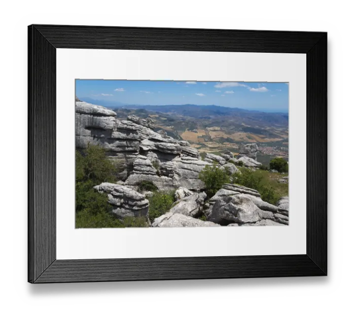 Framed Print : Huge rock formations in front of a wide landscape with fields and mountain ranges under a clear sky