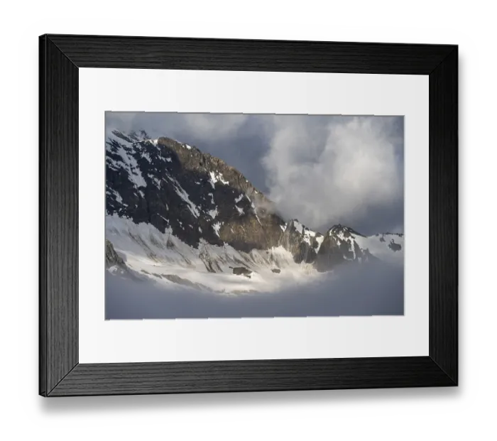 Framed Print : Cloudy, atmospheric mountain landscape with snow-covered mountain peaks