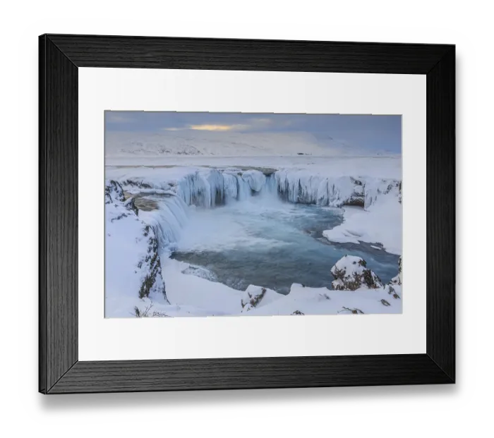Framed Print : Icy waterfall and rapids in front of a mountain landscape