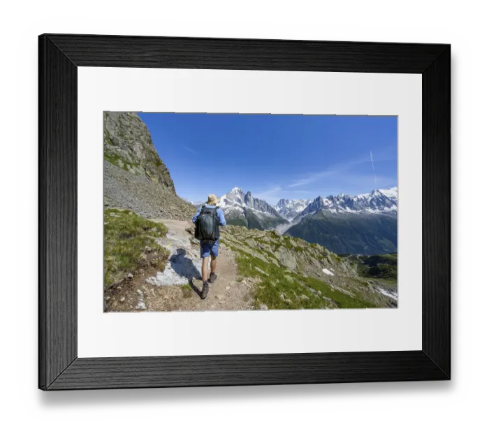Framed Print : Mountaineer on a hiking trail in front of a mountain landscape