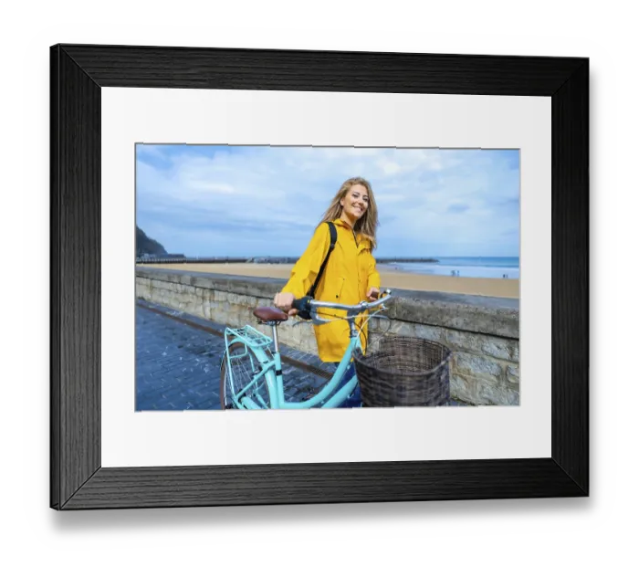 Framed Print : Happy young woman walking with her bicycle on the boardwalk by the beach