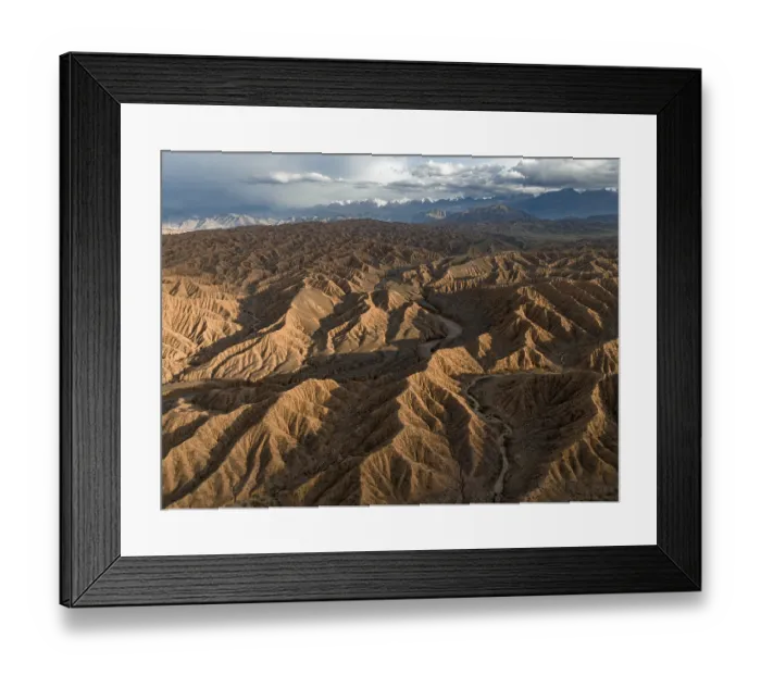 Framed Print : Aerial view, view over eroded hills towards mountains of the Tian Shan Framed Print : Aerial view, view over eroded hills towards mountains of the Tian Shan